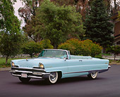 AUT 21 RK0276 04
1956 Light Blue Lincoln Premier Convertible 3/4 Side Headlights On Pavement By Trees And Grass