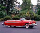 AUT 21 RK0284 03
1951 Red Lincoln Convertible Cosmopolitan 3/4 Side View On Pavement By Trees And Bushes