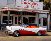AUT 21 RK0293 09
1956 Buick Special Convertible Red And White 3/4 Front View On Pavement By Store