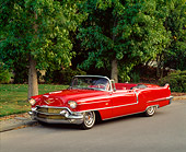 AUT 21 RK0336 03
1956 Red Cadillac Convertible 3/4 Side On Road By Grass And Trees Headlights On