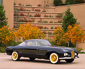 AUT 21 RK0357 03
1953 Black Cadillac Ghia Coupe 3/4 Side View On Pavement By Building And Fall Trees