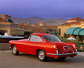 AUT 21 RK0364 03
1957 Jaguar XK-140 Red 3/4 Rear View On Pavement By Buildings