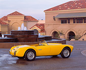 AUT 21 RK0376 09
1953 Yellow Siata Spyder Convertible 3/4 Rear On Wet Pavement By Fountain And Buildings
