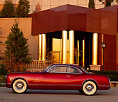AUT 21 RK0390 17
1953 Chrysler Sport Coupe Burgundy Profile In Front Of Lighted Museum At Dusk