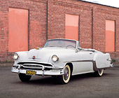 AUT 21 RK0400 08
1954 White Pontiac Starchief Convertible 3/4 Front View On Pavement By Wall Headlights On