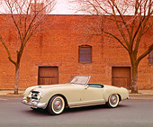 AUT 21 RK0405 11
1953 Gray Nash-Healey Roadster 3/4 Side View On Pavement By Brick Building And Trees