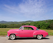 AUT 21 RK0411 09
1951 Custom Pink Chevrolet Side View On Pavement By Grass And Hills Blue Sky