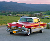 AUT 21 RK0558 05
1956 Packard 400 Red And White 3/4 Front View On Road By Grassy Hills