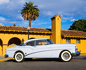AUT 21 RK0644 05
1953 Buick Skylark Hardtop Light Blue Side View On Pavement Building And Palm Tree Background Blue Sky