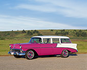 AUT 21 RK0675 03
1956 Chevy Nomad Wagon 4 Door Deep Rose And White Side 3/4 View On Pavement By Grass Blue Sky