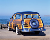 AUT 21 RK0696 03
1950 Ford Woody Station Wagon Blue 3/4 Rear View On Pavement By Ocean Blue Sky