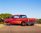 AUT 21 RK0712 02
1957 Chevy Bel Air Red With Flames 3/4 Side View On Pavement By Trees Blue Sky