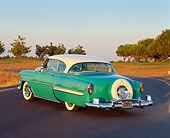 AUT 21 RK0754 04
1954 Chevrolet Bel Air Turquoise And White 3/4 Rear View On Pavement At Dusk Trees