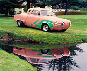 AUT 21 RK0827 01
1951 Studebaker Pro Street Peach And Green 3/4 Side View On Grass Hill By Water Parking Lights On