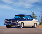 AUT 21 RK0894 01
1955 Chrysler New Yorker Blue And White 3/4 Front View On Pavement Hill Trees Blue Sky