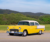 AUT 21 RK0910 10
1955 Chevy 210 Sedan Yellow And White 3/4 Front View On Pavement By Trees And Grass Blue Sky