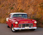 AUT 21 RK0916 02
1955 Chevy Bel Air Red And White 3/4 Front View On Road Headlights On By Dirt Hill