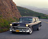 AUT 21 RK0920 02
1956 Chevy Nomad Wagon Black 3/4 Front View On Road Headlights On Side Of Hill At Dusk