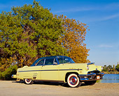 AUT 21 RK0943 03
1954 Mercury Monterey Sun Valley Yellow Low 3/4 Side View On Dirt By Trees And Water Blue Sky