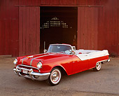 AUT 21 RK0956 05
1955 Pontiac Star Chief Convertible Red And White Side 3/4 View On Pavement In Front Of Barn Headlights On