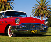 AUT 21 RK0991 01
1955 Buick Roadmaster Convertible Red Low 3/4 Front View On Grass Palm Trees Blue Sky