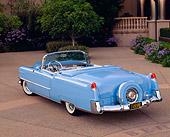 AUT 21 RK1071 02
1955 Cadillac Convertible Blue 3/4 Rear View On Pavement By Trees And Bushes