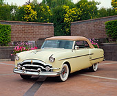 AUT 21 RK1081 02
1954 Packard Convertible Yellow 3/4 Front View On Brick Pavement By Brick Wall Water Fountain