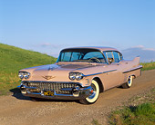 AUT 21 RK1213 02
1958 Cadillac De Ville Sedan Pink 3/4 Front View On Dirt By Grass Hills