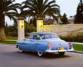 AUT 21 RK1257 01
1950 Cadillac Blue 3/4 Rear View On Pavement By Wall And Palm Trees At Dusk