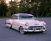 AUT 21 RK1259 06
1953 Chevy Bel Air Lowrider Beige And Brown 3/4 Side View On Pavement By Trees