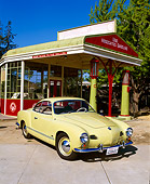 AUT 21 RK1277 09
1958 Karmann Ghia Yellow 3/4 Front View By Old Gas Station Blue Sky