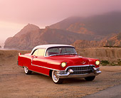 AUT 21 RK1305 14
1955 Cadillac Coupe Red And White 3/4 Front View On Sand Rock Mountains Fog Red Filtered
