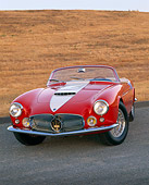 AUT 21 RK1344 04
1957 Maserati A6G/2000 Frua Spider Red With White Stripe 3/4 Front View On Pavement By Dry Grass Hill