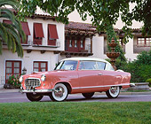 AUT 21 RK1387 05
1955 AMC Nash Rambler Country Club Pink Low 3/4 Side View By Building And Trees