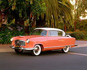 AUT 21 RK1396 02
1955 AMC Nash Rambler Country Club Pink 3/4 Side View On Pavement By Trees