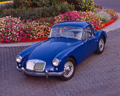 AUT 21 RK1460 05
1958 MGA Coupe Blue 3/4 Overhead View On Pavement By Flowers