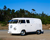 AUT 21 RK1602 02
1957 VW Panel Double Door With Windows Safaris White 3/4 Front View On Gravel Trees Background