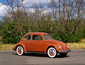 AUT 21 RK1627 01
1957 VW Bug Oval Window Coral Red 3/4 Side View On Pavement By Bushes And Trees