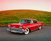 AUT 21 RK1709 01
1958 Chevrolet Impala Sport Coupe Red Lowrider 3/4 Front View On Pavement By Grass Hill Filtered