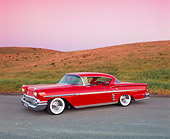 AUT 21 RK1710 01
1958 Chevrolet Impala Sport Coupe Red Lowrider 3/4 Side View On Pavement By Grass Hills Filtered