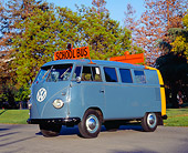 AUT 21 RK1727 02
1955 VW School Bus Prototype Blue And Yellow Side 3/4 View On Pavement By Trees