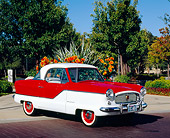 AUT 21 RK1907 04
1959 Nash Metropolitan Red And White 3/4 Side View On Pavement By Orange Flowers