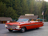AUT 21 RK2003 01
1959 Chevrolet Impala Convertible Red 3/4 Front View On Pavement By Cabin And Trees
