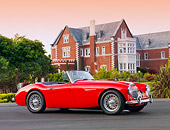 AUT 22 BK0015 01
1960 Austin-Healey 3000 BT7 Roadster Red 3/4 Front View On Pavement By Mansion