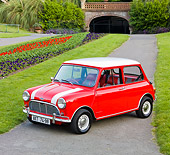 AUT 22 BK0027 01
1961 Mini Mark I Red With White Stripes 3/4 Front View On Pavement By Garden