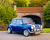 AUT 22 BK0033 01
1965 Mini Blue With Silver Stripes 3/4 Front View On Pavement By Bridge