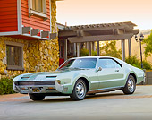 AUT 22 BK0041 01
1966 Oldsmobile Toronado Green Silver 3/4 Front View On Pavement By House