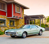 AUT 22 BK0042 01
1966 Oldsmobile Toronado Green Silver 3/4 Front View On Pavement By House