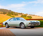 AUT 22 BK0045 01
1966 Oldsmobile Toronado Green Silver 3/4 Front View On Pavement By Fence And Hills