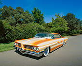 AUT 22 RK1802 02
1962 Pontiac Grand Prix Custom Orange 3/4 Front View On Pavement By Trees